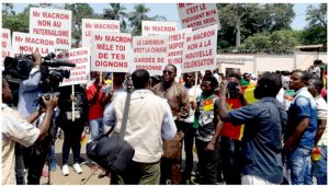 Cameroonian youths protesting with placards in front of the French Embassy in Yaounde