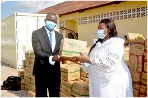  Nestle Official, Roland Banzeu handing  over food items to beneficiary